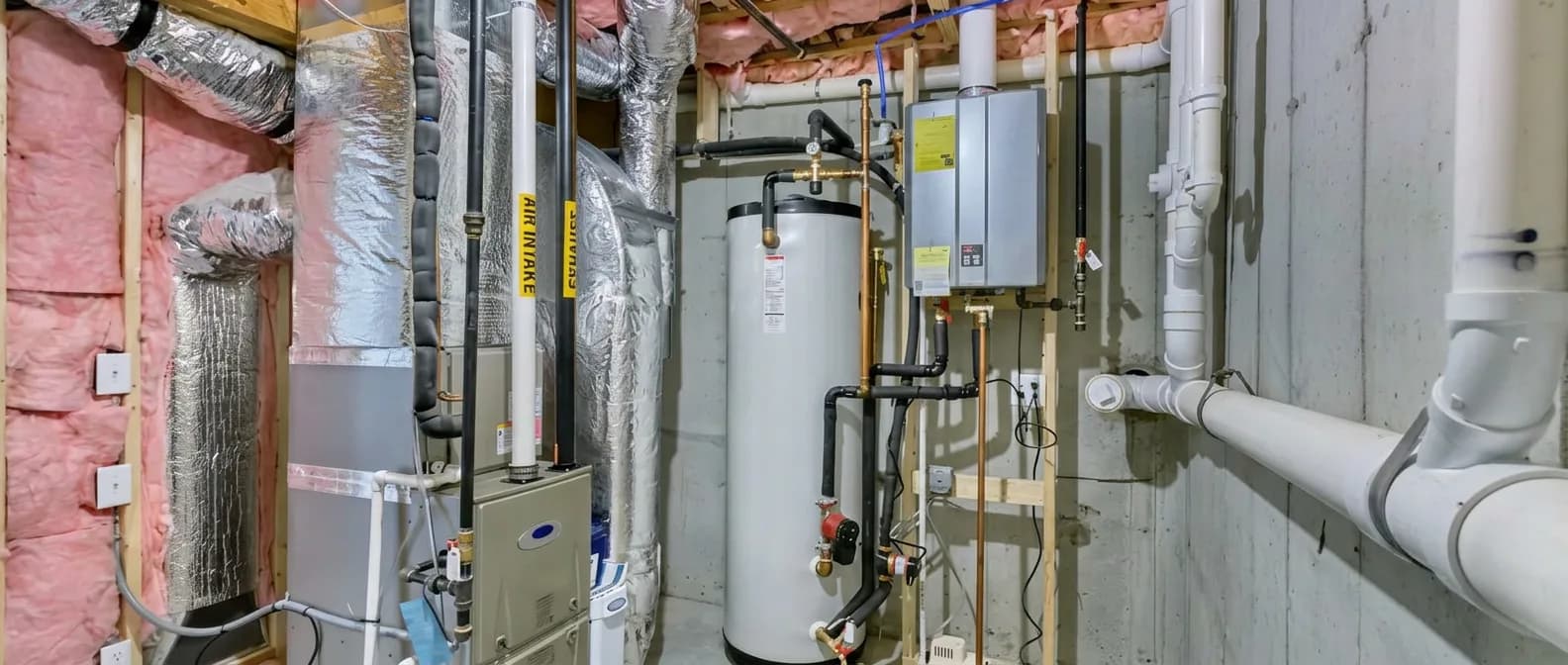Residential mechanical room with furnace, water heater, and tankless unit
